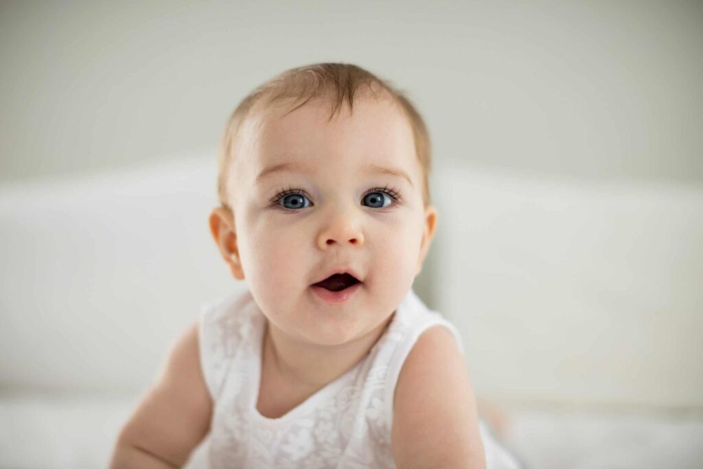 Portrait of cute smiling baby girl in bedroom